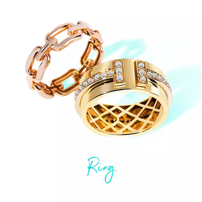 Two gold rings including a chain design and a wide gemstone-studded design with a chic style