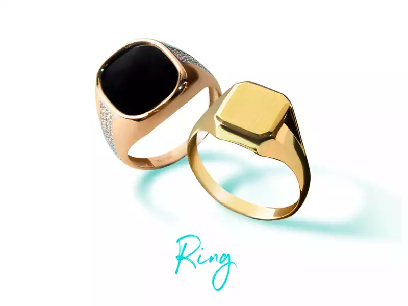 Two men's gold rings, one with a black gem and the other with a smooth gold surface.